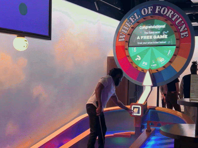 gif of a man at the Wheel of Fortune hole doing a little jig