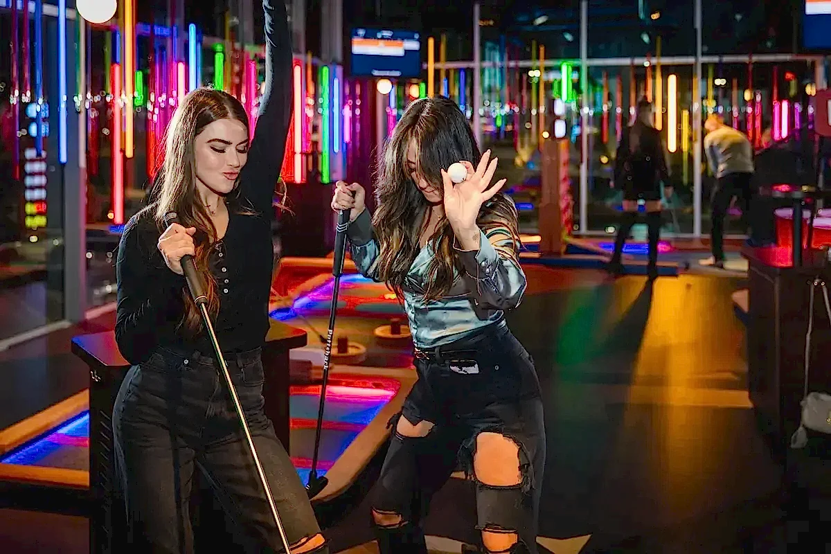 two girls celebrating holding putts and a golf ball