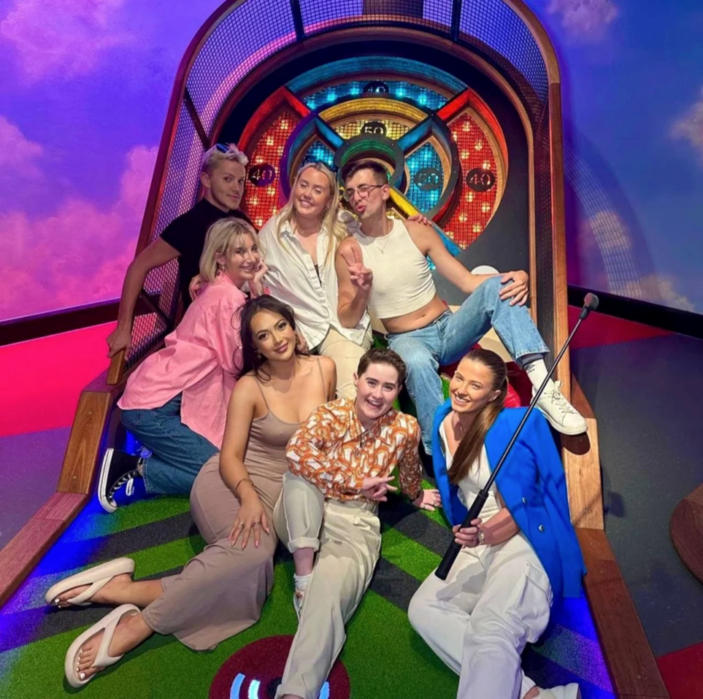 Group of adults posing on ski-ball hole