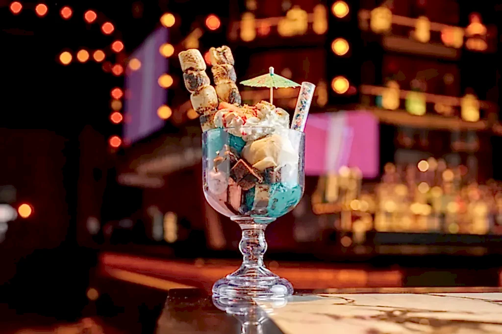 A specialty dessert with marshmallows and a cocktail umbrella
